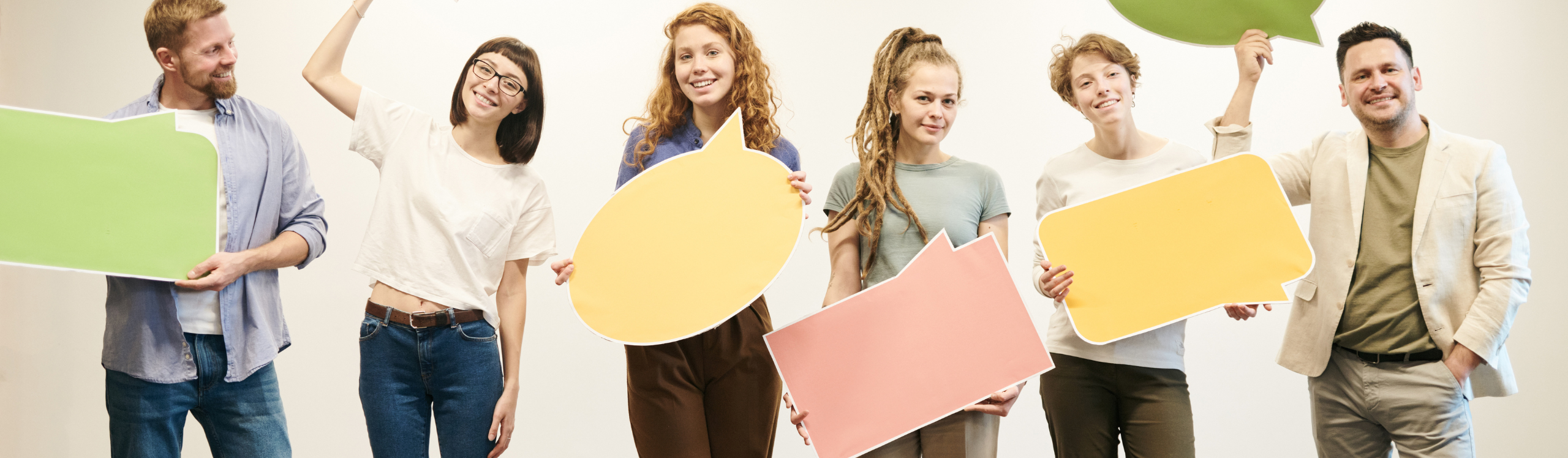 People holding up cutouts of speech and text bubbles, white background.