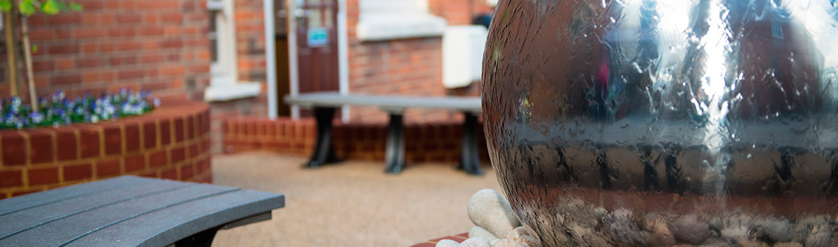 Metal decoration with bench outside of community buildings.