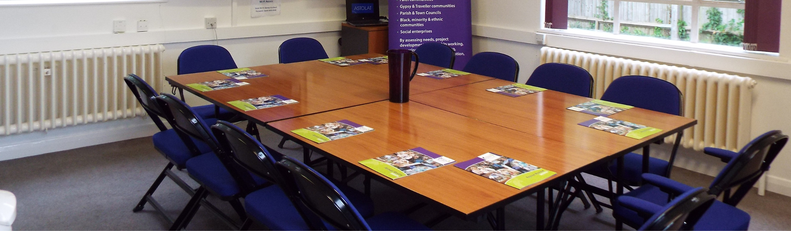 A meeting room with the surrey community action leaflets on the table.