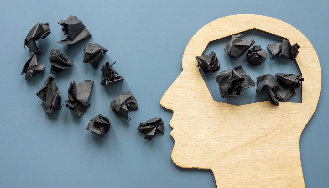 Pieces of paper screwed up in ball which sit inside a wooden head and flow out of the mouth