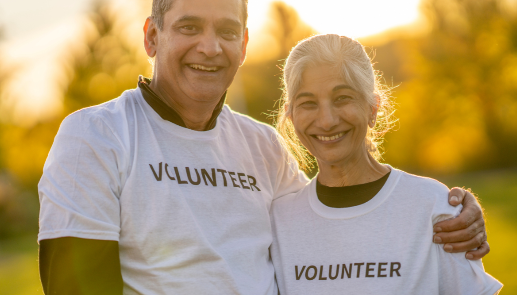 A man and a woman wearing tops which say volunteer